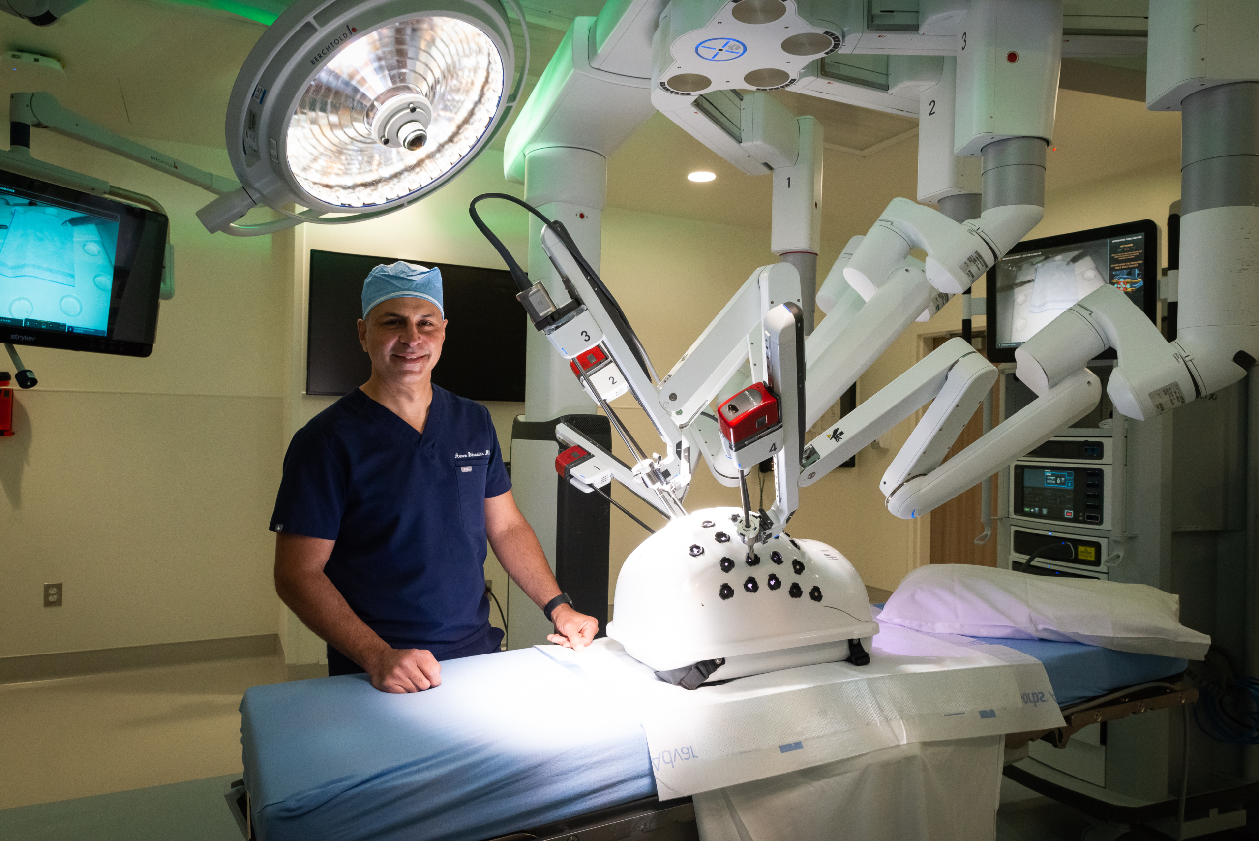 Doctor standing in operating room with robotic surgery machinery