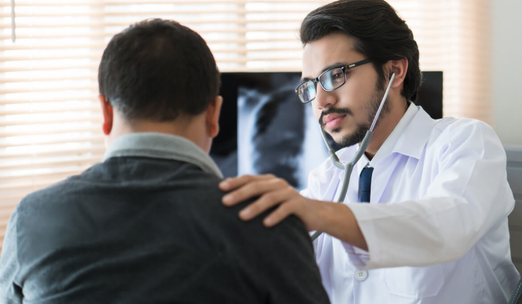 doctor talking to male patient, with his hand on patient's shoulder