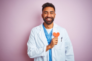 Doctor holding paper heart to his chest